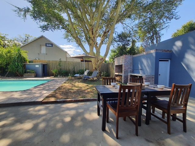 The built braai and outdoor dining table, with the pool beyond